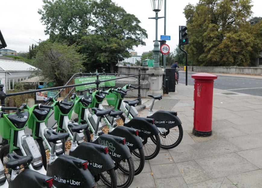 Lime bikes parked near a bridge.