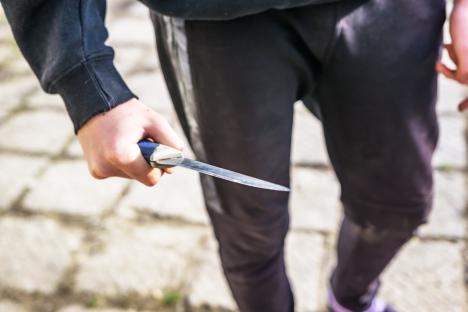 Close-up of a young person holding a knife.