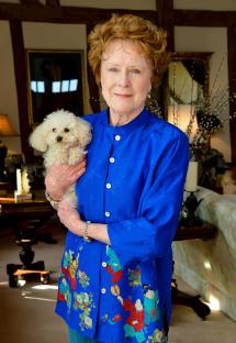 Judy Parfitt holding a small white dog.