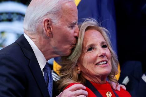 President Biden kissing First Lady Jill Biden on the forehead at a ceremony.