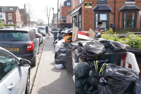 Overflowing trash bins on a residential street.