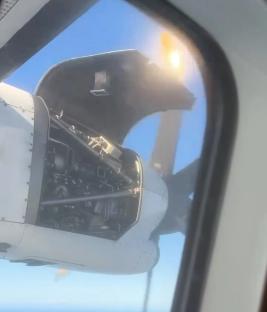 Airplane engine cover open mid-flight.