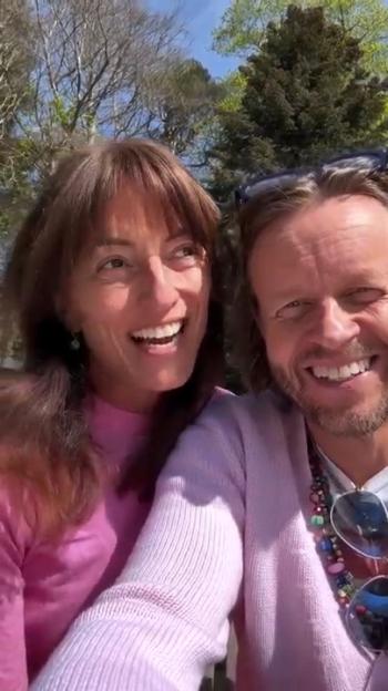 Close-up selfie of a smiling couple outdoors.