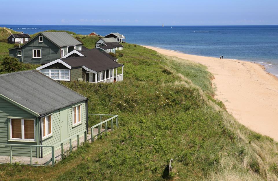Beach houses on a dune overlooking the ocean.