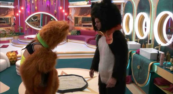 Two people in cat costumes in a brightly colored room.