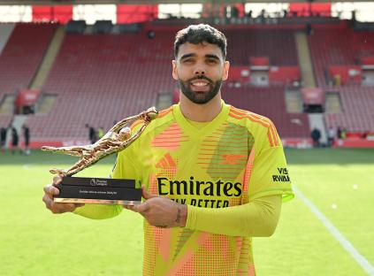 Arsenal goalkeeper David Raya holding the Premier League Golden Glove award.