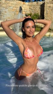 Woman in a floral bikini in a hot tub.