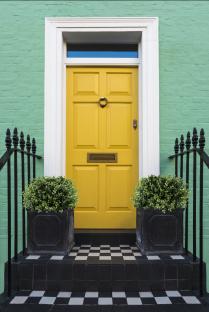 Yellow front door on a teal building.