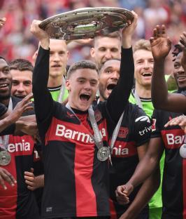 Florian Wirtz of Bayer Leverkusen holding the championship trophy.