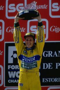 Michael Schumacher holding a trophy after winning a Grand Prix.