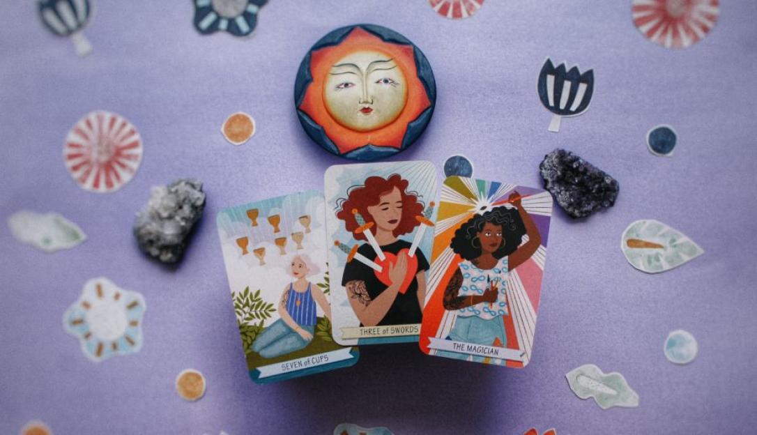 Illustration of three tarot cards: Seven of Cups, Three of Swords, and The Magician, surrounded by crystals and decorative elements.
