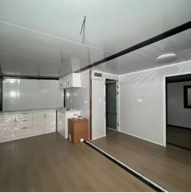 Interior view of a small, prefabricated home with a kitchen and additional rooms.