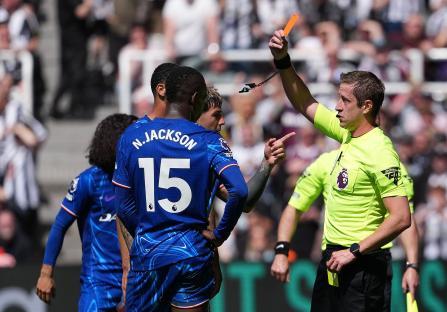 Referee showing a red card to a soccer player.