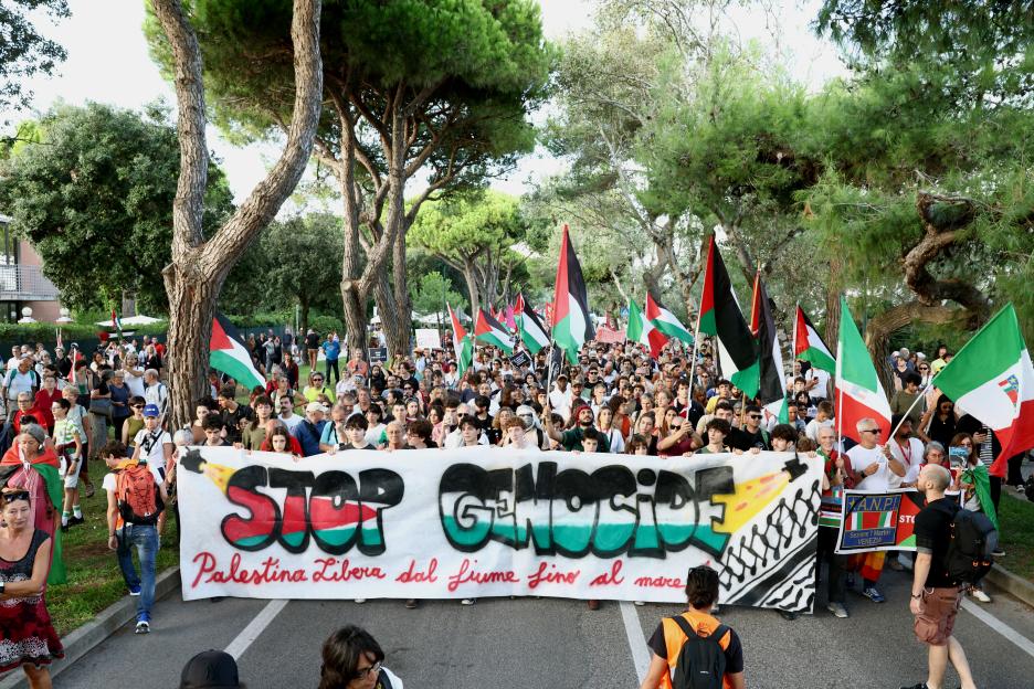 Pro-Palestine protest with banner reading "Stop Genocide."