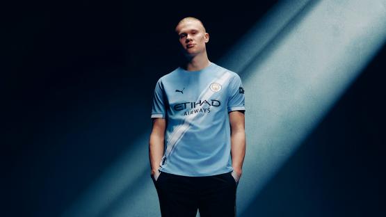 Man in Manchester City soccer jersey.