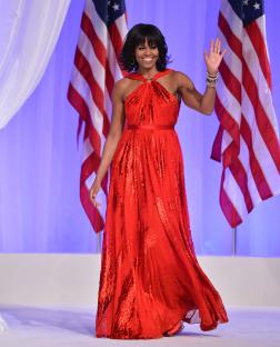 Michelle Obama in a red gown waving at the Commander-in-Chief's Ball.