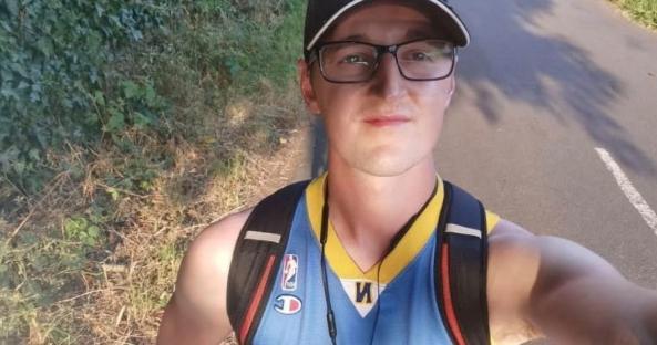 Man in a basketball jersey exercising outdoors.