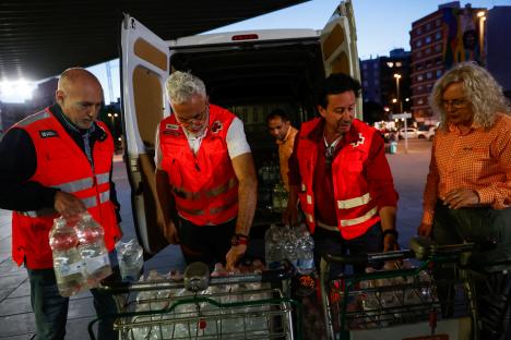 Red Cross volunteers load water bottles onto carts.