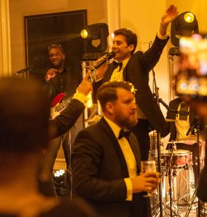 A man singing into a microphone at a charity event.
