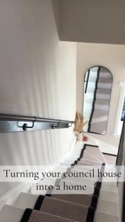 Renovated staircase with new carpeting and a wall-mounted rail.