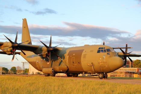 A U.S. Air Force Lockheed C-130 Hercules aircraft on the tarmac with people nearby.