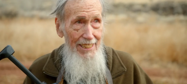 Smiling elderly man with long white beard.