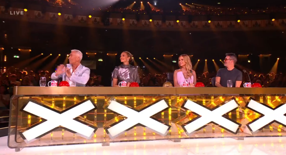 Screenshot of four judges at a televised talent show.
