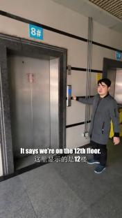 Person standing in front of an elevator, the display shows the 12th floor.