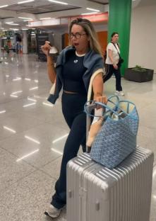 Samantha Kenny at an airport, holding a boarding pass.