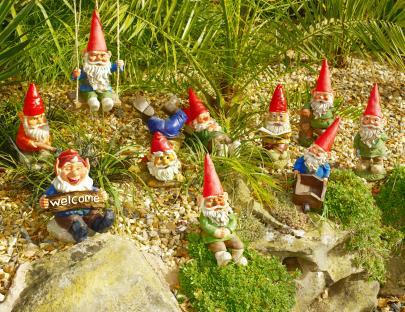 Family of garden gnomes in a garden setting.