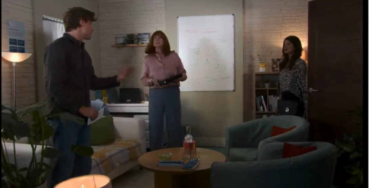 Three people in an office having a tense conversation.