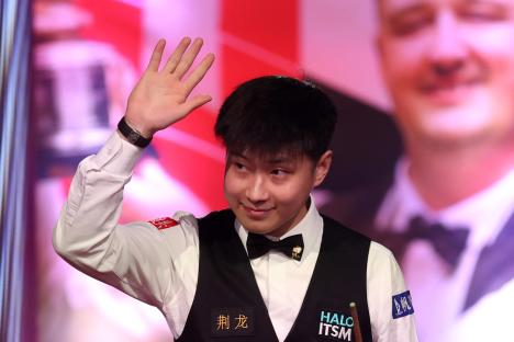 Zhao Xintong of China waves to the audience at a snooker match.