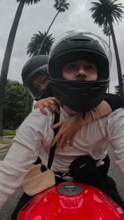 Couple on a motorcycle wearing helmets.