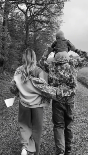 Black and white photo of a family walking away from the camera.