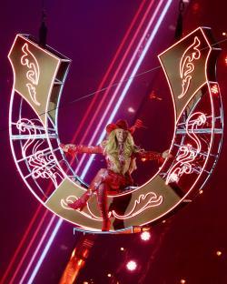 Beyoncé performing on a horseshoe-shaped stage prop.
