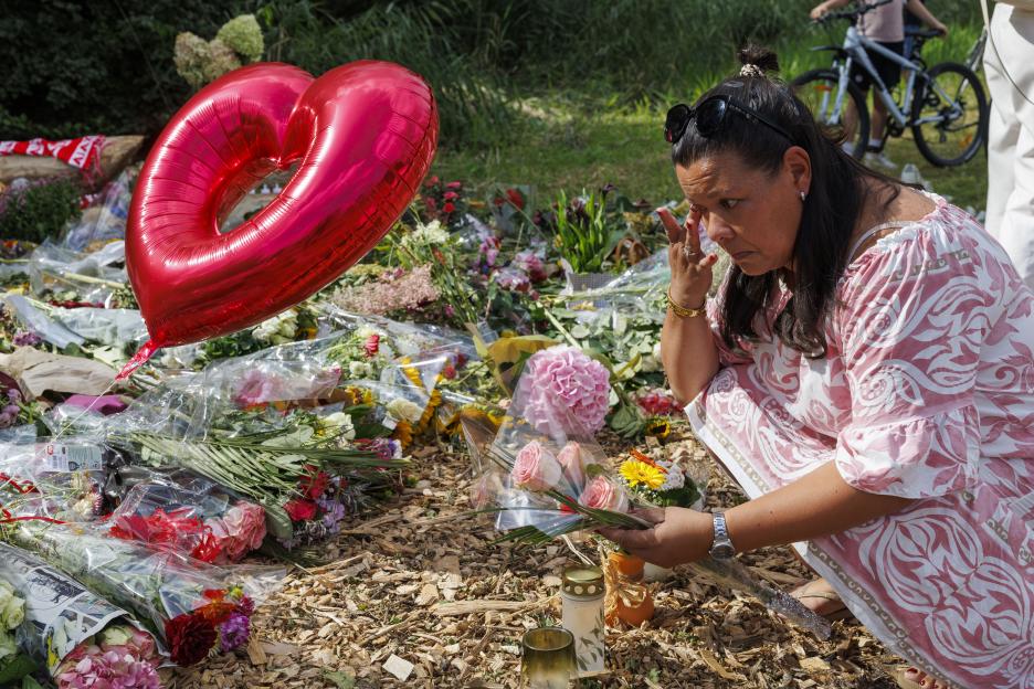 Woman laying flowers at a memorial.