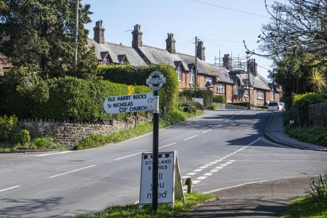 Studland village road sign and houses.