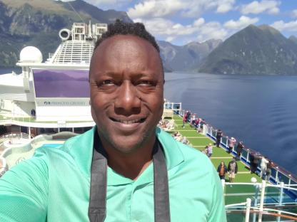 Man on a Princess Cruises ship in a fjord.