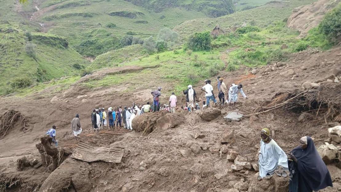 Aftermath of a landslide in western Sudan, showing people surveying the damage.