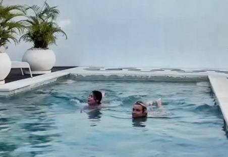 Video still of two women skinny dipping in a shared villa pool.