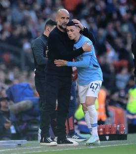 Pep Guardiola embracing Phil Foden on the pitch.