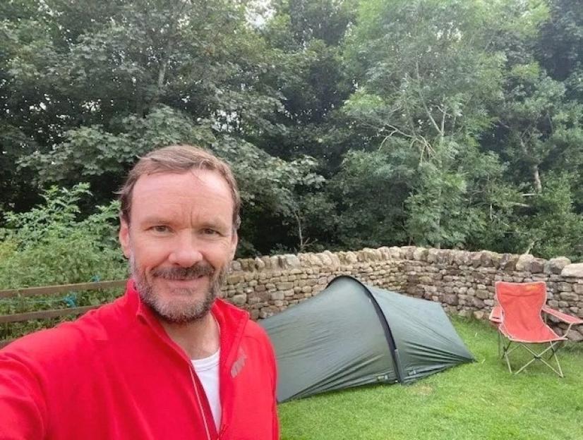 Stephen Chamberlain taking a selfie at a campsite.