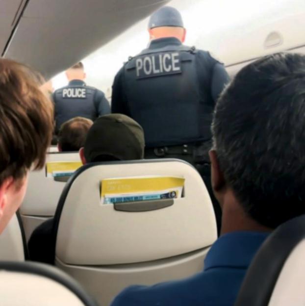 Police officers on an airplane.