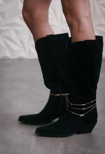 Black cowboy boots with ankle chains.