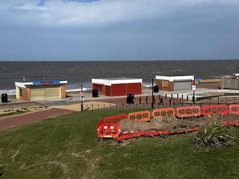 Rhyl seaside with closed kiosks and construction barriers.
