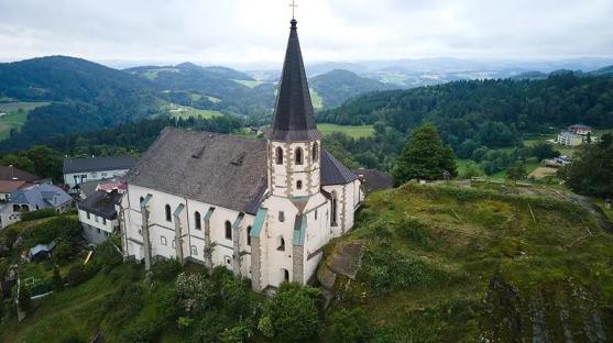Aerial view of a church on a hilltop overlooking a valley.