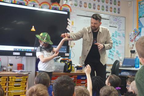 A man presenting to a classroom of children.