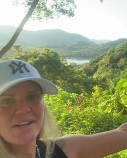 Kerry Katona in front of a scenic landscape.