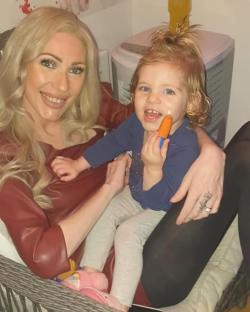 A woman holding her toddler daughter.