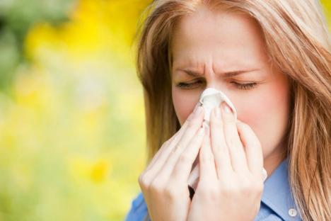 Woman with hay fever blowing her nose.